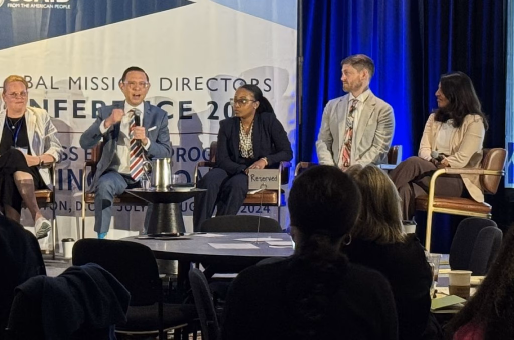 An executive panel taking questions from an audience at a leadership conference